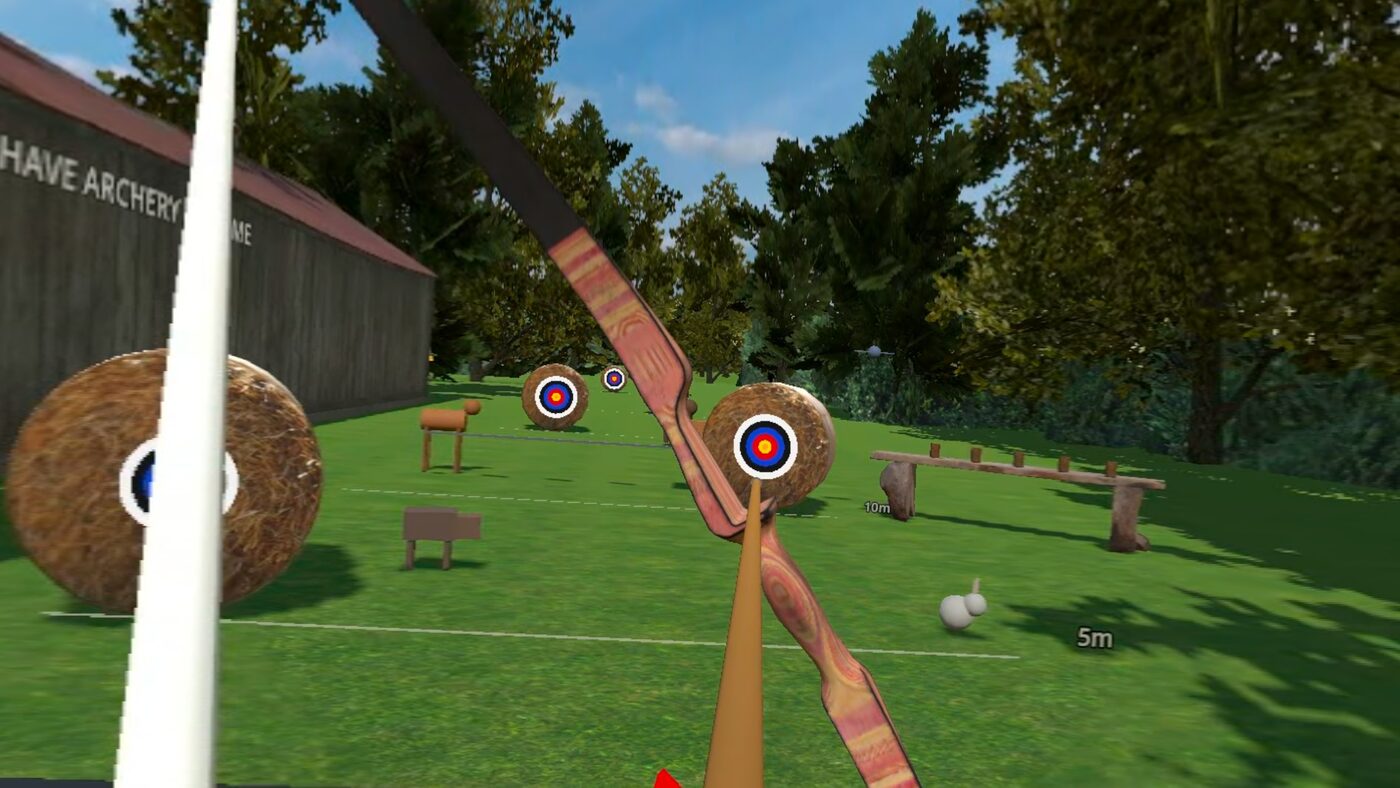 First-person view down a drawn bow, arrow nocked and aimed at hay bale targets across a grass range.